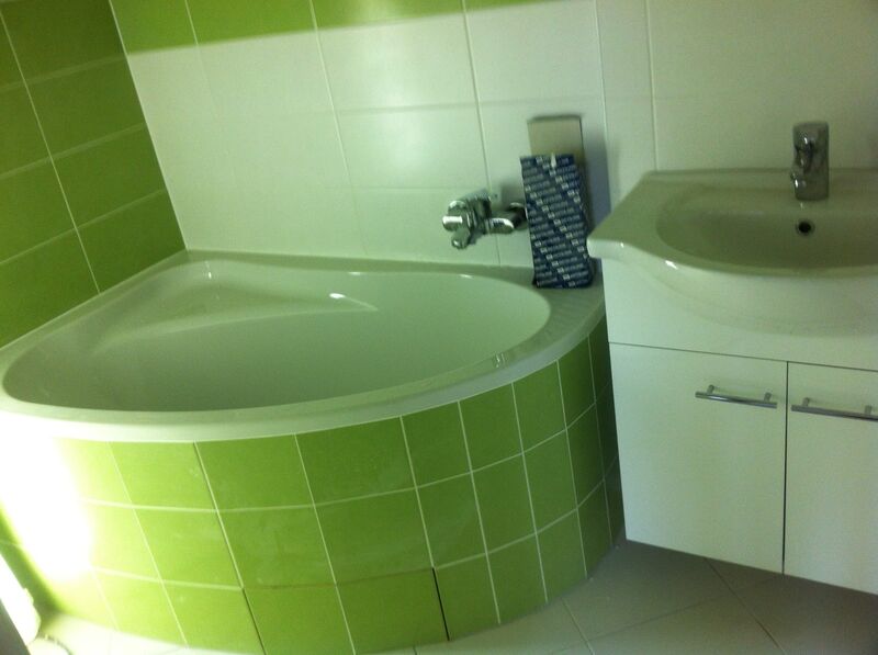 Bad mit grünen Fliesen und Eckbadewanne