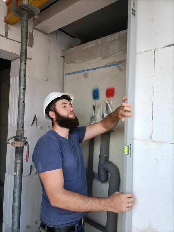 Monteur von WorkEurope bei der Installation an einer Wand