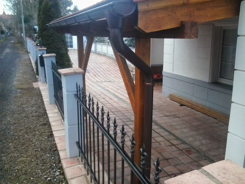 Zaun mit Pfeilern entlang eines Hauses